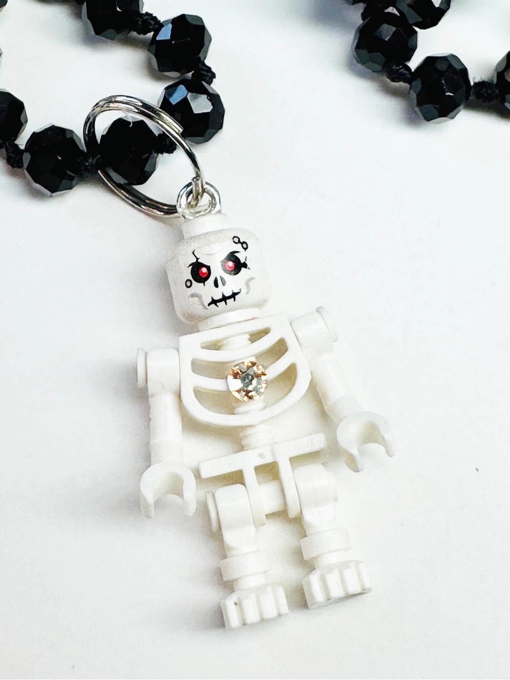 Lego Skeleton Charm on a long 36” Black Beaded Necklace.